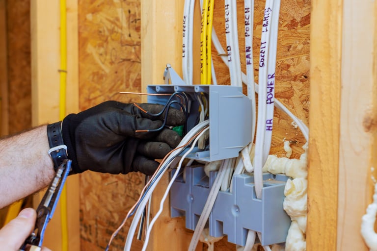 Electrician connecting wires in circuit box during renovation