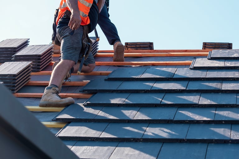 Builder placing roof tiles