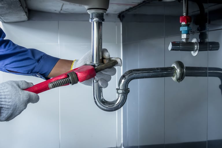 Plumber hands holding wrench doing repair work